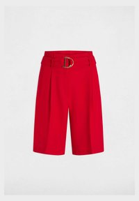 Pantaloni shorts rossi su misura con gamba ampia, dotati di una grande fibbia dorata e pieghe sul davanti. Tessuto liscio e strutturato.