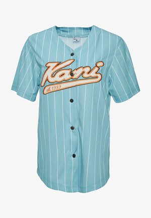 Türkiissinine nööpidega jerss, millel on valged vertikaalsed triibud, ja millel on oranž trükk "Kani" koos aastaga "est. 1989" allpool. Sile kangastekstuuri.