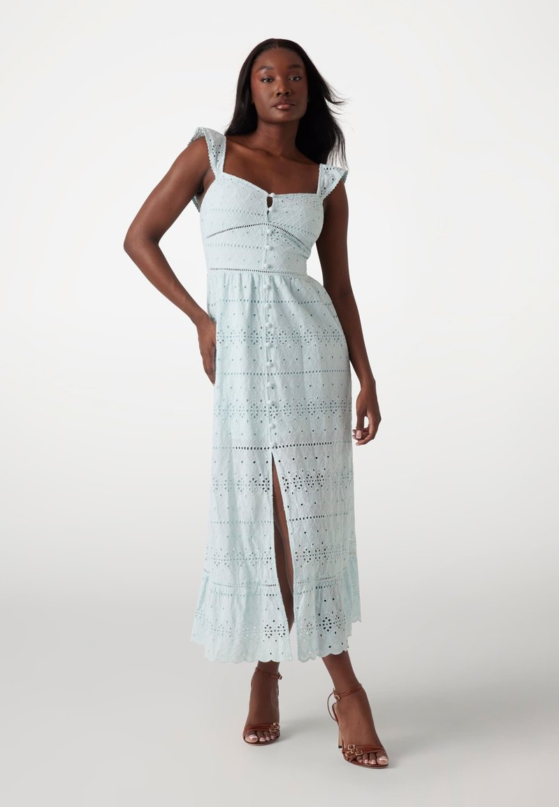 Light blue lace dress with square neckline, short ruffled sleeves, and front slit. Textured floral patterns throughout. Brown heeled sandals.