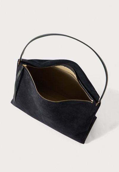 Melna zamšādas rokassoma ar gludu faktūru, rāvējslēdzēja aizdari un plānu ādas rokturi. Iekšpusē gaišā, kontrastējošā krāsā.