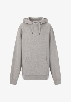 Grå hættetrøje med snøre, parret med grå joggers. Har elastiske manchetter og talje. Båret med hvide sneakers og en blå kasket.