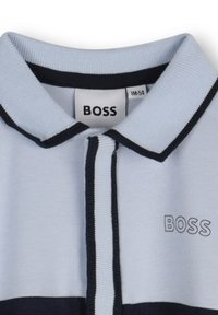 Light blue polo shirt with a navy trim, featuring a ribbed collar and the logo "BOSS" embroidered in navy on the chest.