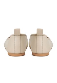 Ballerine in pelle beige con una texture liscia, forma rotonda e un tacco basso. La parte posteriore presenta una linguetta corta per facilitare l'indosso.