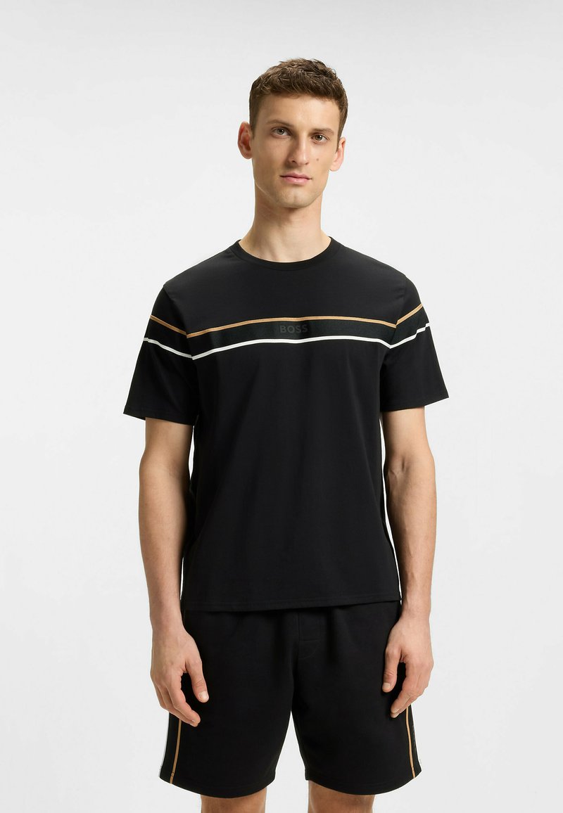 Black T-shirt with crew neck features horizontal stripes in gold and white, and a "BOSS" logo in the center. Paired with black shorts.