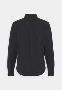 Camicia nera a maniche lunghe con colletto classico, tessuto testurizzato, polsini con bottoni e orlo curvo, vista da dietro.