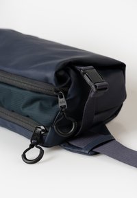 Marine rugzak met een slank ontwerp, een gestructureerd oppervlak, dubbele rits en een verstelbare schouderriem. Inclusief zwarte hardwareaccenten.