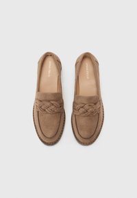 Bruna mocka slip-on skor med flätad frontdetalj och en kontrasterande sydd sula. Slät inredning med subtil logotyp.