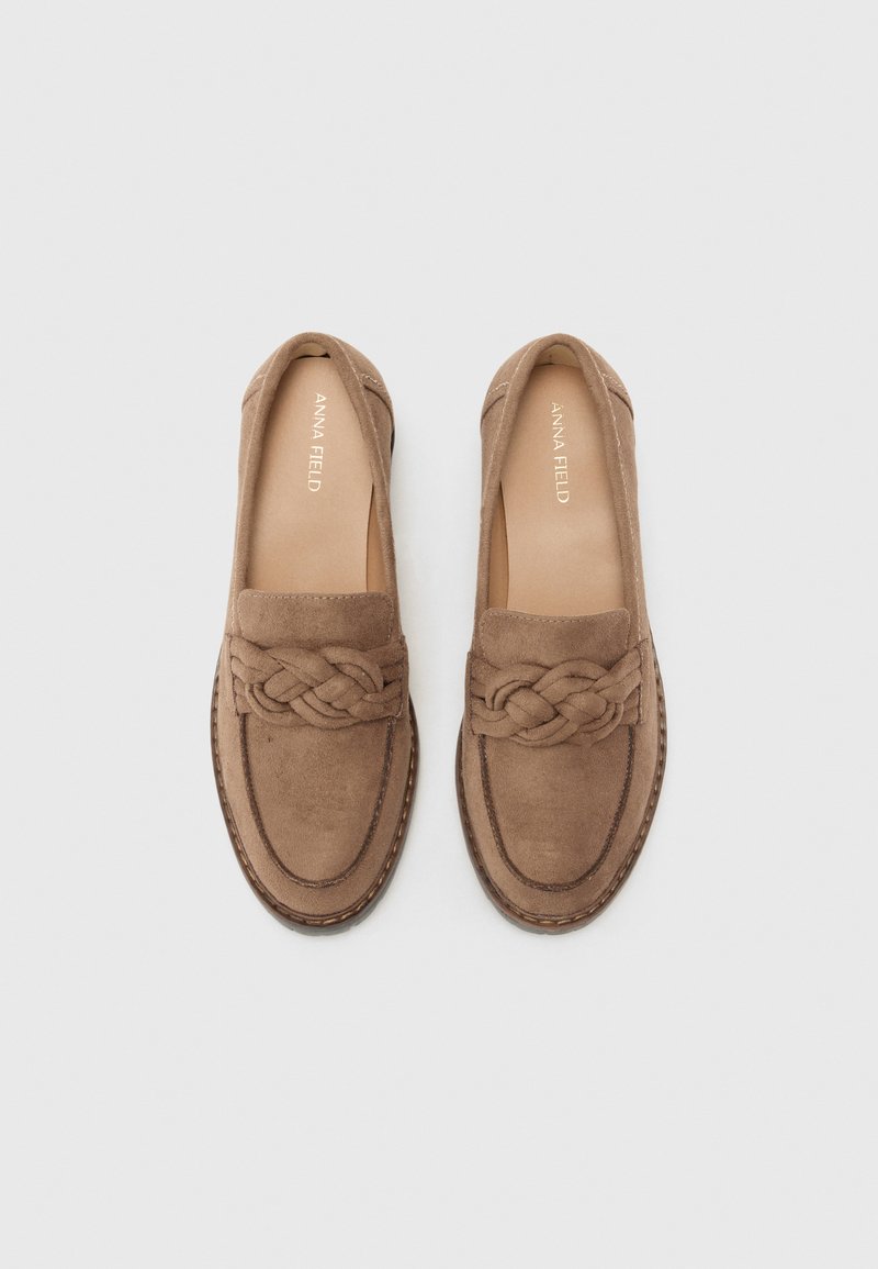 Scarpe slip-on in suede marrone con dettagli intrecciati nella parte anteriore e suola cucita a contrasto. Rivestimento interno liscio con un marchio discreto.