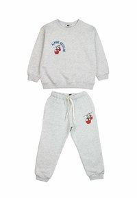 Grijze sweatshirt en bijpassende sweatpants, beide gemaakt van zachte stof. De sweatshirt heeft de tekst "ALPINE SKI CLUB" en een ontwerp van een rode kabelbaan.