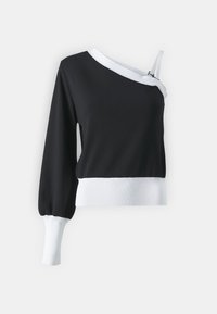 Haut noir à manches longues avec un ourlet côtelé blanc et des détails de bretelles, présentant un design décolleté et un tissu texturé.