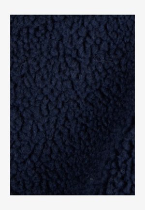 Material de forro polar azul marino con una superficie texturada y suave que presenta un patrón en relieve. La tela parece suave y peluda.