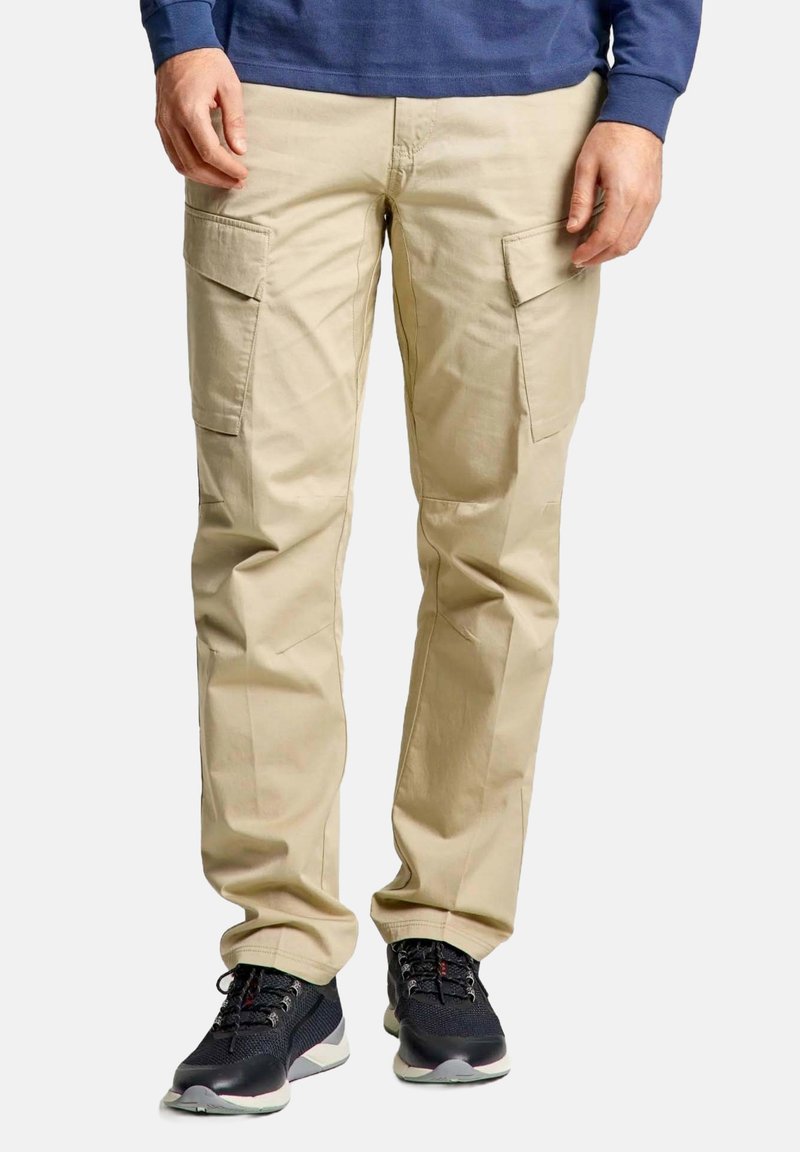 Beige cargobroek met meerdere zijzakken, rechtlopende pasvorm en een gladde textuur. Draag het met zwarte sportschoenen.