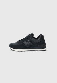 Czarne buty sportowe z połączeniem teksturowanych materiałów, w tym akcentów z zamszu i wężowej skóry. Posiadają białą podeszwę środkową i czarną podeszwę zewnętrzną.