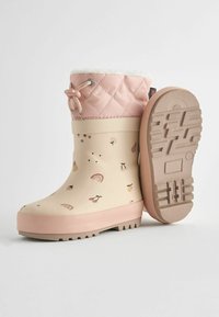 Bottes de pluie en caoutchouc rose et beige avec un dessus matelassé, une doublure en fourrure et des motifs de fruits ludiques. Semelle à crampons pour une meilleure adhérence et stabilité.