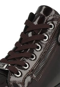 Baskets en cuir verni marron avec lacets marron, œillets en métal et zip sur le côté. Fini texturé donnant un aspect brillant.