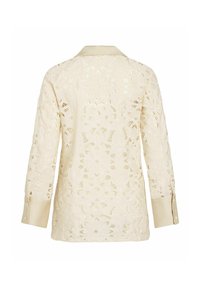 Blouse crème à manches longues en dentelle avec motif floral découpé et poignets et col unis, vue de dos.