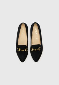 Μαύρα σουέντ μπαλαρίνες με μυτερή μύτη, διακοσμητική χρυσή αλυσίδα στο μπροστινό μέρος και μαλακό πάτο. Το εμπορικό όνομα "Gabor" είναι ορατό στο εσωτερικό.