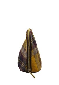 Pochette triangulaire avec une fermeture éclair dorée, fabriquée en tissu écossais multicolore présentant des tons de jaune, violet et gris, et une étiquette attachée.