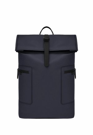 Ciemnoniebieski plecak z zamknięciem zwijanym na górze z czarnym paskiem z klamrą, dwoma bocznymi kieszeniami na zamek oraz górnym uchwytem do noszenia, na białym tle.