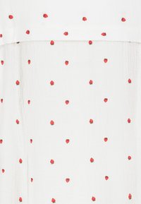 White fabric with a textured surface featuring scattered red strawberry embroidery. The design is playful and evenly distributed across the material.