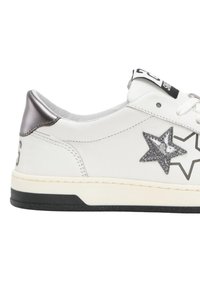 Sneaker bianca con finitura in pelle liscia, design a stella argentata, accento argento sul tallone e suola in gomma nera. Chiusura con lacci.