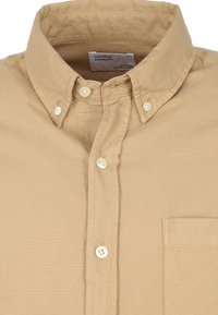 Khaki button-up shirt gemaakt van katoen. Heeft een klassieke kraag, een borstzak en witte knopen op de sluiting en mouwen. Gladde textuur.