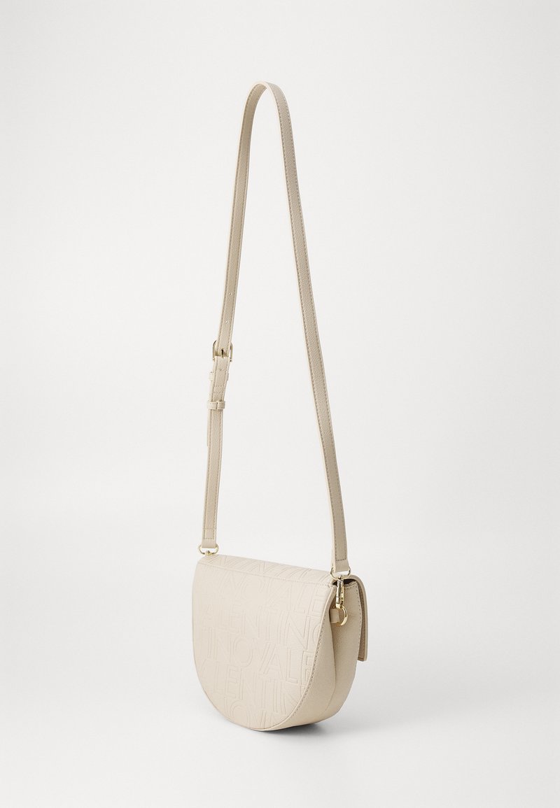 Borsa a tracolla beige con forma curva e design a logo goffrato e testurizzato. Cinghia regolabile e finiture in tonalità dorate.
