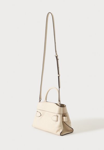 Sac à main en cuir crème avec une poignée supérieure et une longue bandoulière réglable, forme rectangulaire structurée et détails sombres sur les bords.