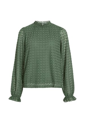 Blusa verde a maniche lunghe in tessuto testurizzato con motivo esagonale, colletto alto e polsini arricciati. Presenta una lucentezza sottile.