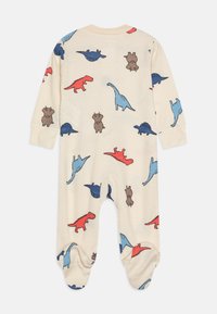 Dolgoročni bodi v svetlo bež barvi z vzorcem dinozavrov v rdeči, modri in rjavi barvi. Ima zaprte noge in pritrditev na vratu z gumbi.