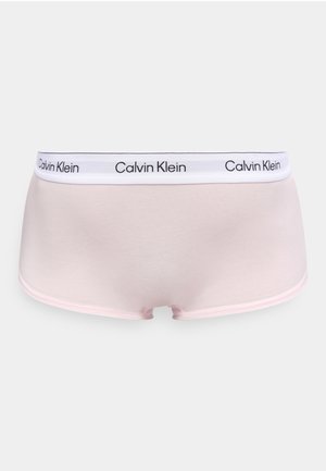Gaiši rozā Calvin Klein sieviešu biksītes boyshort stilā ar baltu jostu, uz kuras atkārtoti ir melns logotipa teksts.
