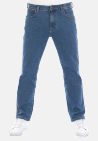 Jeans in denim blu con vestibilità dritta, cinque tasche, chiusura con bottone in metallo e cuciture chiare. Abbinati a sneakers bianche.