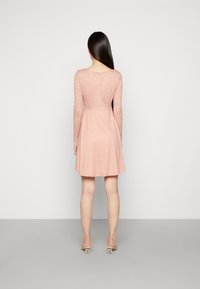 Vestido rosa com mangas longas de renda, corpete ajustado e saia em A, com uma textura suave e detalhes de design subtil.