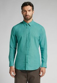 Turquoise overhemd met lange mouwen en een button-down kraag, gemaakt van een subtiele текстuurd stof. Voorzien van een voorflap met knopen en een gebogen zoom.
