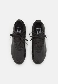 Černé sportovní boty s strukturálním povrchem, kulatou špičkou, perforovanými detaily a plochými tkaničkami. Na vložce je logo.