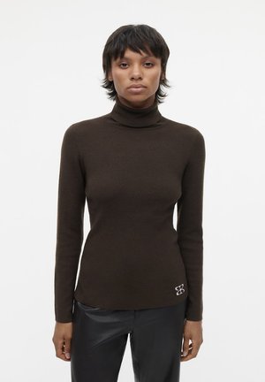 Bruine, aansluitende coltrui in een geribde textuur, met een klein logo-accent aan de onderzijde rechts. Lange mouwen, slim design.