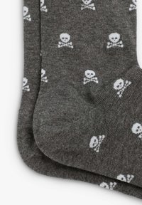 Calze da crew grigie realizzate in un tessuto morbido, con un motivo ripetuto di teschi e ossa incrociate bianche. Texture liscia con punta rinforzata.
