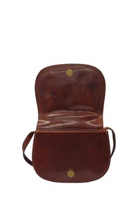 Sac en cuir marron en bandoulière de forme arrondie, avec un intérieur brillant et une fermeture à pression en laiton ; il présente une sangle réglable et une texture douce.