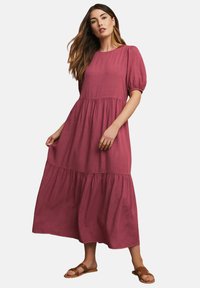 Langärmliges Kleid mit Puffärmeln aus tiefrosafarbenem Stoff, mit einem gestuften Design, Rundhalsausschnitt und sanfter, fließender Textur.