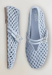 Ballerines tissées bleues avec un motif texturé et un design à double sangle. Deux boucles métalliques accentuent les sangles, le tout reposant sur une semelle plate.