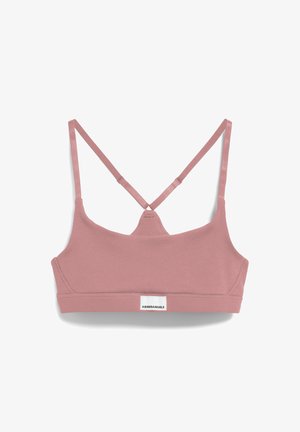 Lichtroze katoenen bralette met een geribbelde textuur, met een crisscross rugontwerp en een klein wit merklabel aan de onderkant.