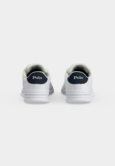 Ζευγάρι λευκά αθλητικά παπούτσια Polo Ralph Lauren, εμφανίζονται από πίσω, με ναυτικό μπλε ταμπελάκια στη φτέρνα που εμφανίζουν το λογότυπο "Polo" με λευκό κείμενο.