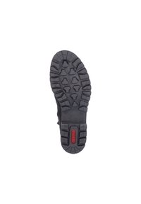 Semelle de botte en caoutchouc noire avec un motif de bande de roulement robuste, dotée de crampons angulaires et arrondis pour une meilleure traction. Marquage rouge situé au niveau du talon.