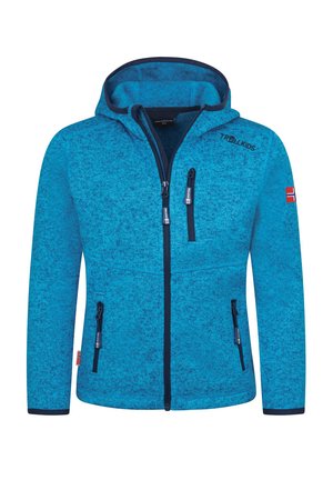 Blue hooded zip-up jacket with black zippers, three front pockets, "Trollkids" text on chest, and a small red flag patch on left sleeve.