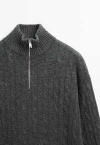 Maglione a maglia grigio scuro con colletto alto a costine, chiusura a mezza zip e motivo a treccia. Tessuto morbido e maniche lunghe.