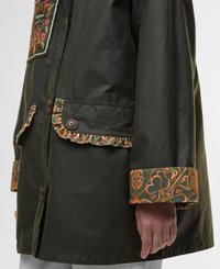 Green cotton jacket with ornate orange and green floral patterns on the cuffs and pocket. Features brown buttons and ruffled accents.