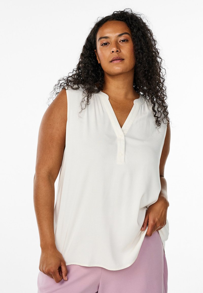 Blusa sin mangas blanca con escote en V y pequeña tapilla de botones. Tejido suave con un diseño fluido y caída delicada.