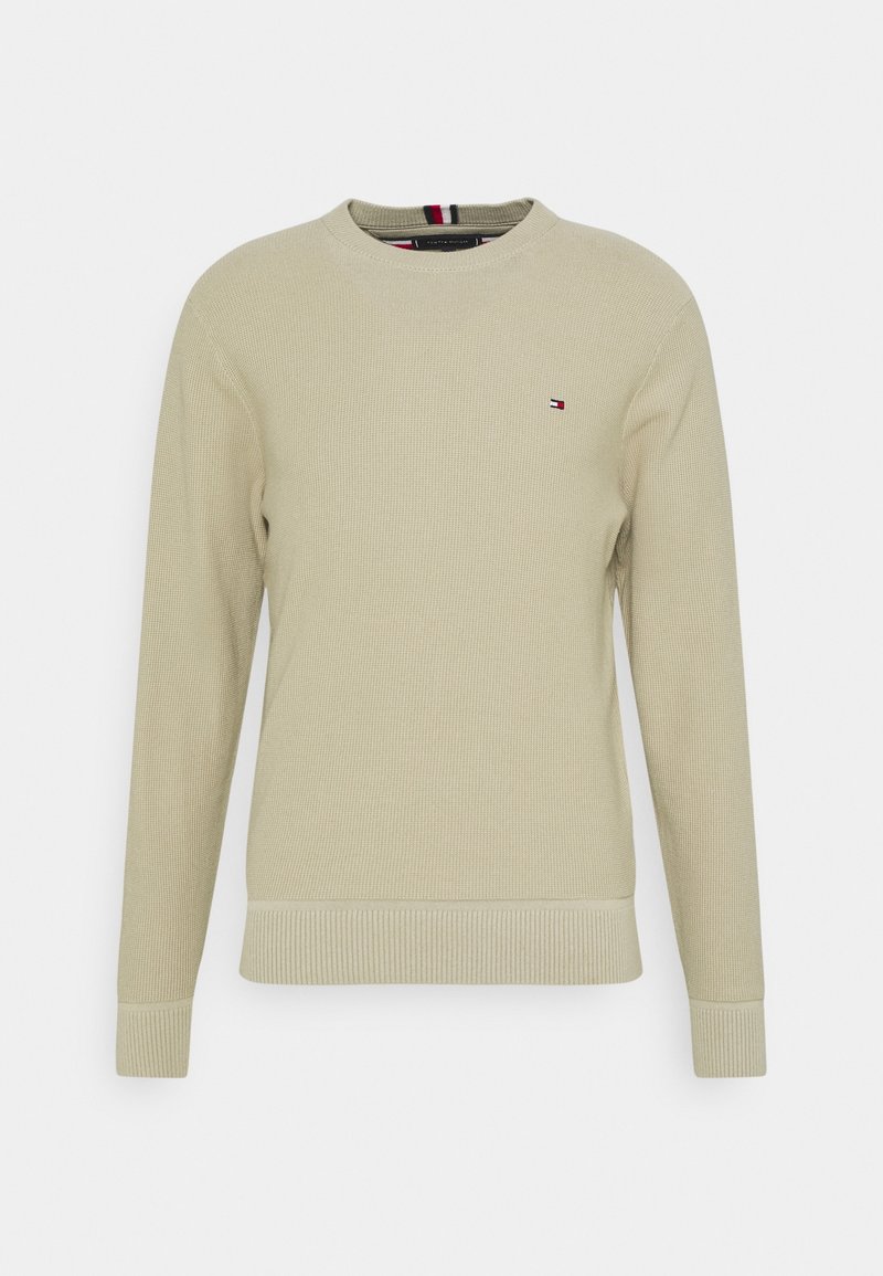 Pull en maille beige à manches longues avec col rond et petit logo brodé rouge, blanc et bleu sur la poitrine gauche.