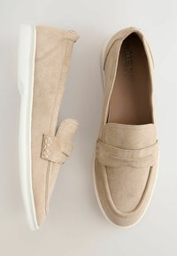 Mocassins en daim beige avec semelles blanches, présentant une bande cousue sur le devant, vus de dessus et de profil.