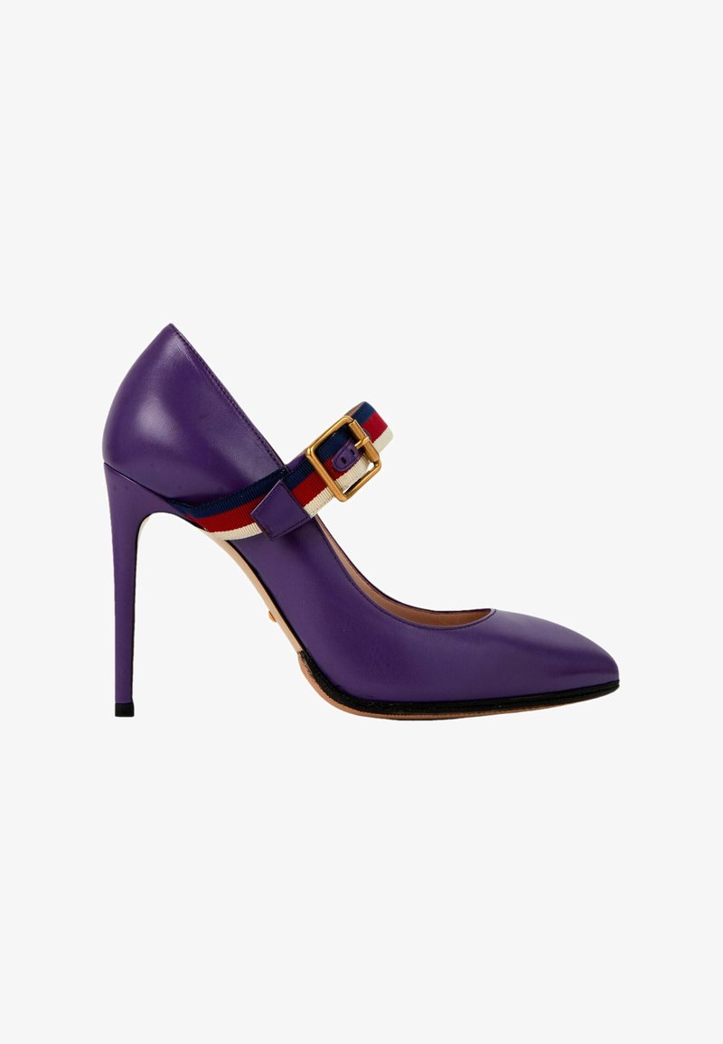 Escarpin violet à talon haut avec bout pointu et bride rayée rouge, blanche et bleue avec boucle dorée.